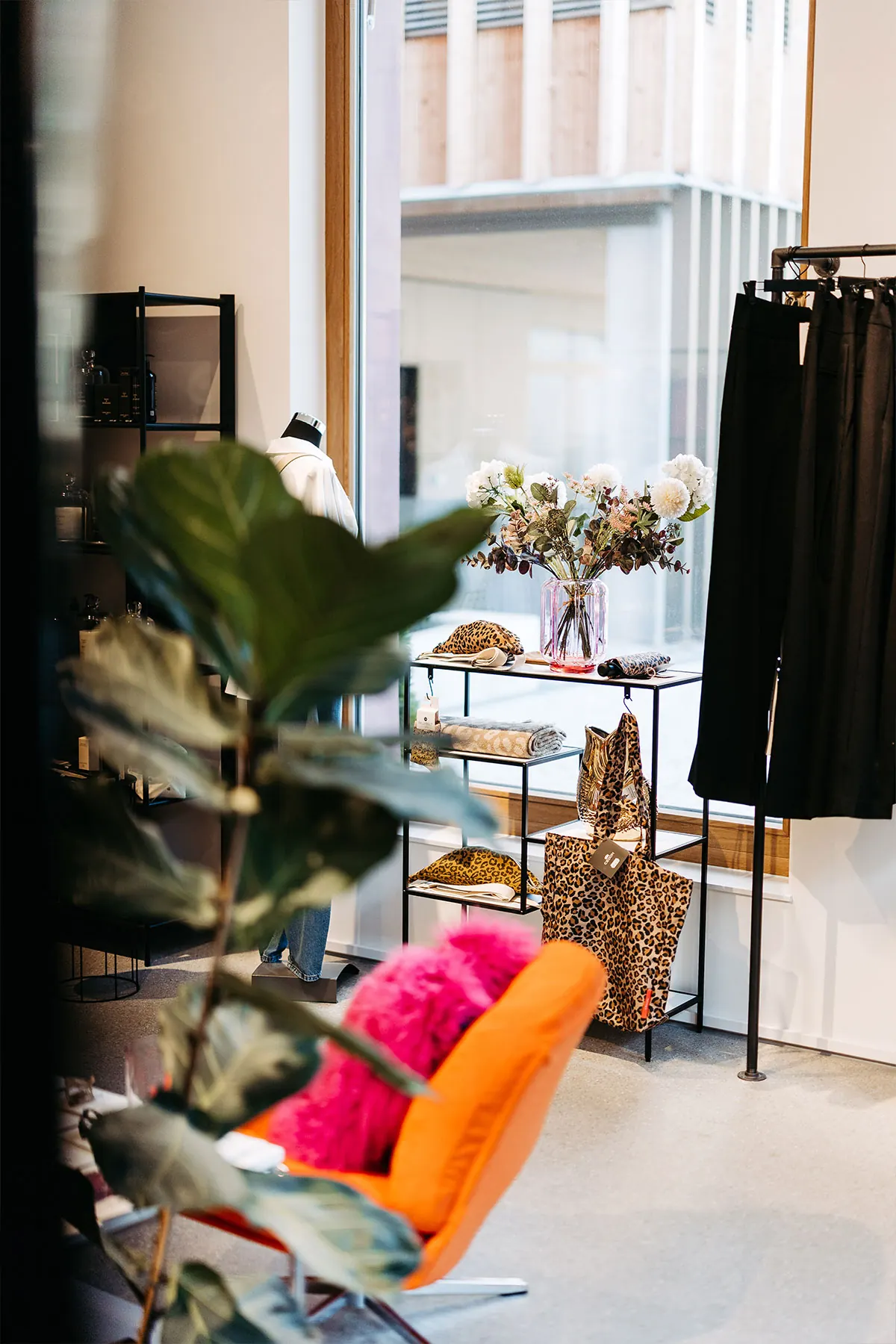 Regal mit Taschen und Blumen